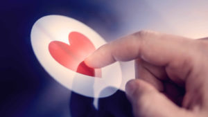 Finger tapper på et hjerte-ikon