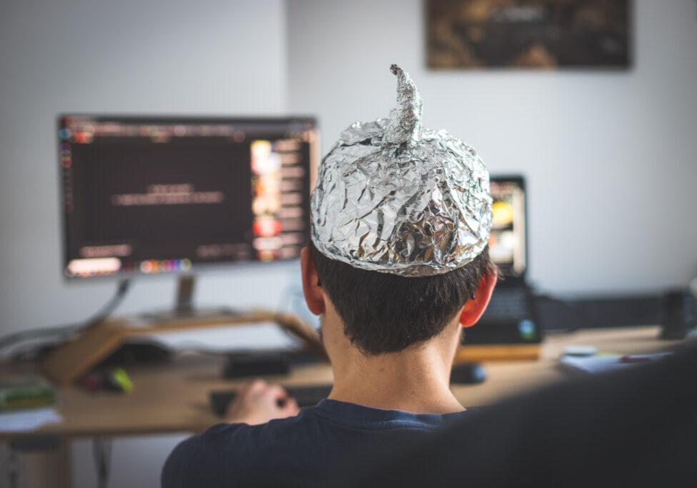 Young man is wearing aluminum cap, conspiracy theory concept